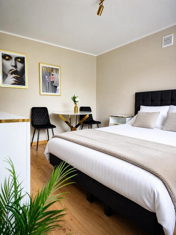ein Schlafzimmer mit einem großen Bett und einem Tisch in der Unterkunft Golden Studio in Płock