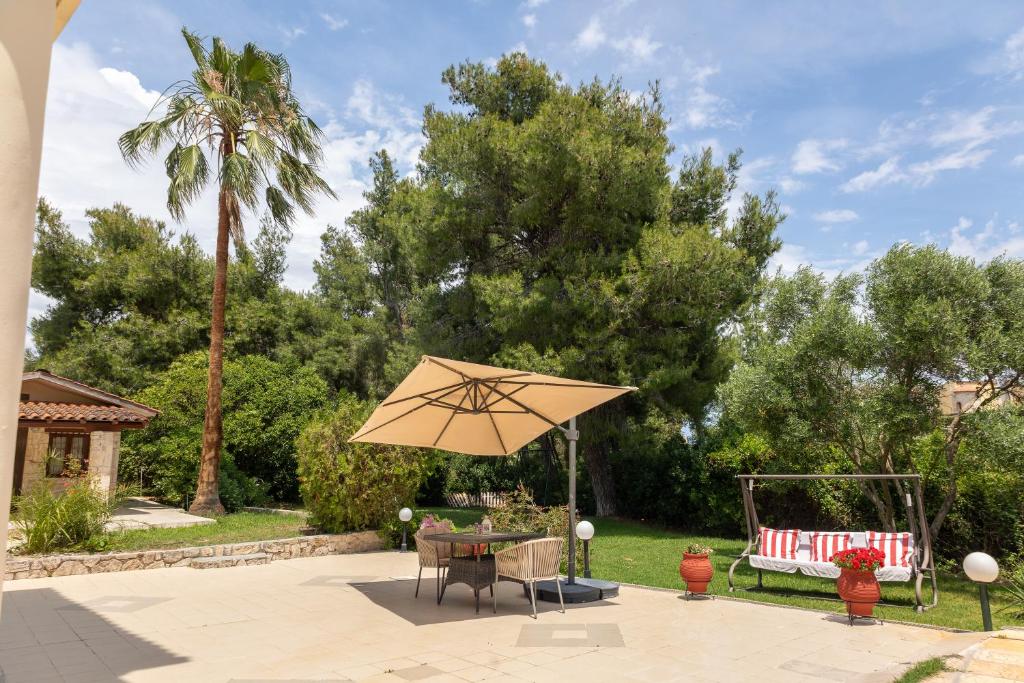 a patio with a table and an umbrella at Casa Stefanos in Afitos