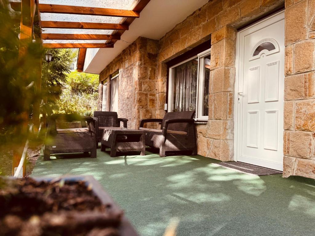 a porch with chairs and a white door at Árnyas Tölgy in Kismaros