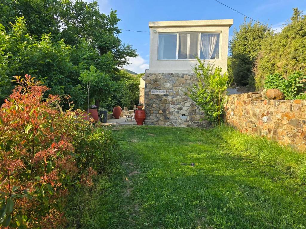 a stone house with a window in a yard at Petra Homes Temenia in Teménia