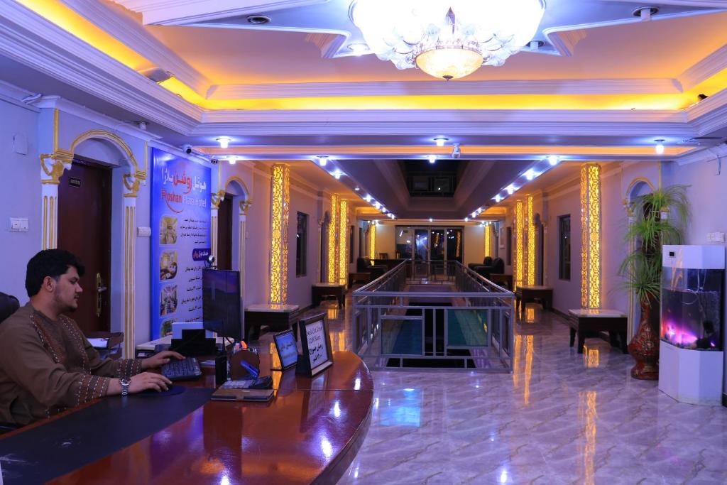 a man sitting at a bar in a hotel lobby at Roshan Plaza Hotel in Kabul