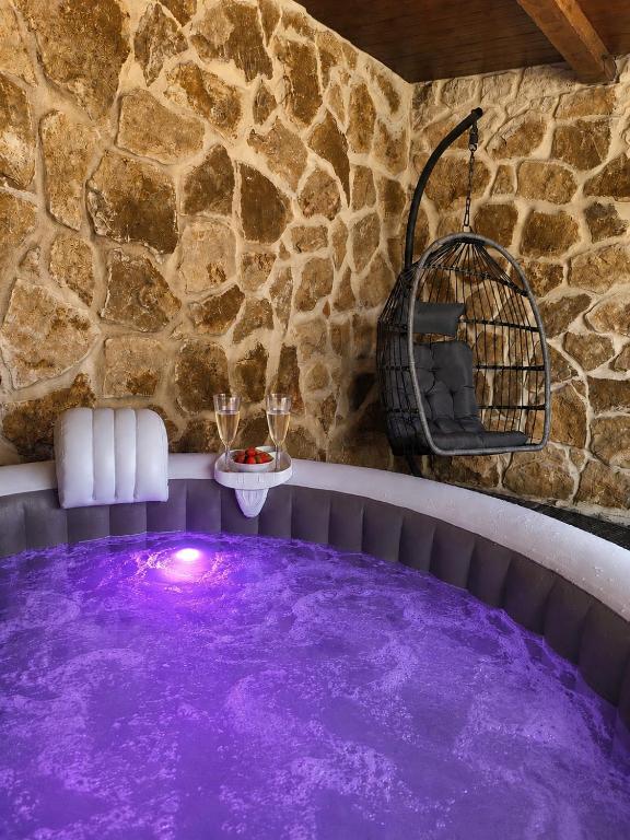 a purple heated plunge pool with a stone wall at Casa con piscina y jacuzzi in Pontevedra
