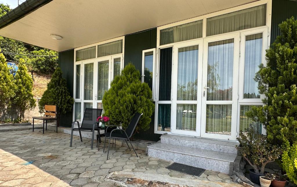 a green house with white windows and a patio at Krupitskiy House in Chakvi