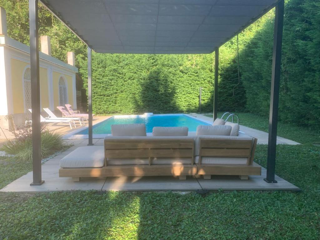 a patio with a couch and a swimming pool at Camere con piscina Tenuta BRICCHETTO in Castagneto Po