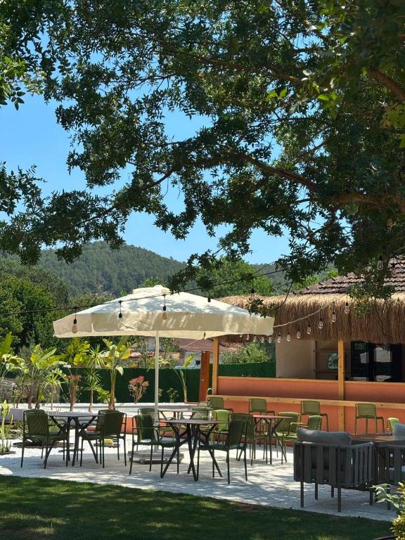 a group of tables and chairs under an umbrella at Hanımın Çiftliği Tents&Drinks in Fethiye