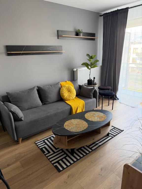 a living room with a couch and a table at Apartament Grey 2 pokojowy z balkonem w Warszawie z parkingiem podziemnym in Warsaw