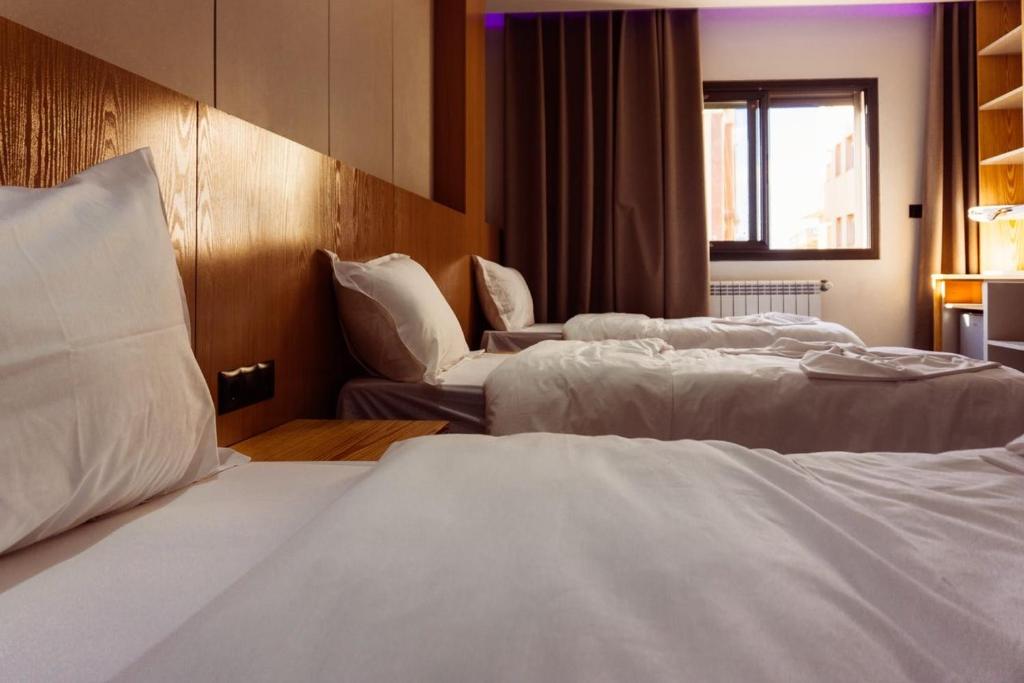 a hotel room with two beds and a window at Hostel Tamim in Fort de lʼEau