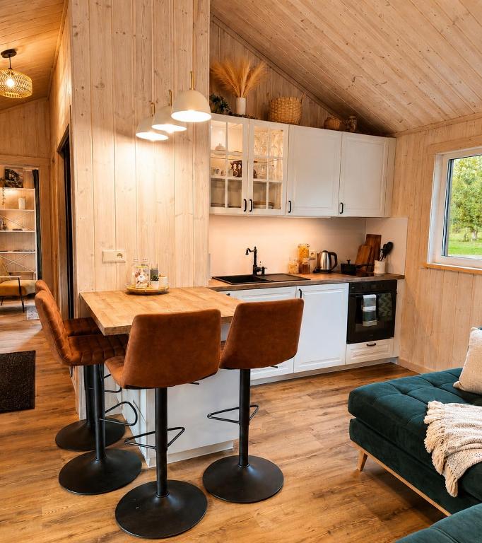a kitchen with a table and chairs in a room at Escape to Nature - Piparmētras in Mērsrags