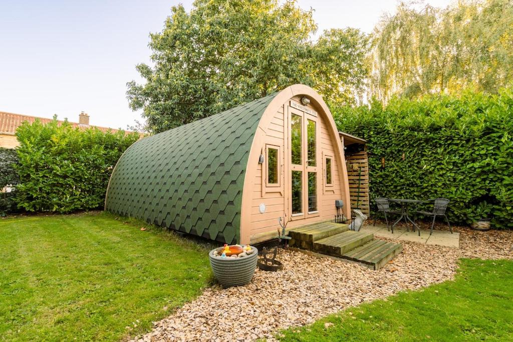 a small dome house in a yard with a patio at The Chestnuts Pod with private garden. in Eccles