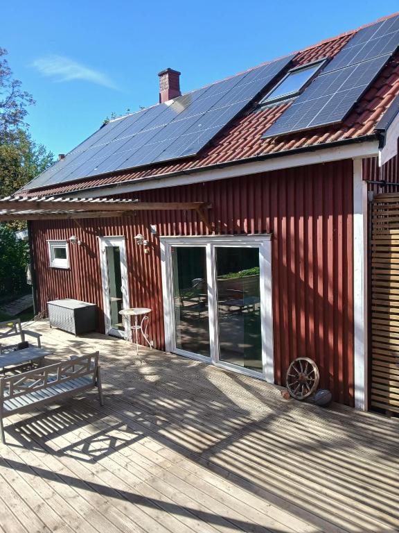 a red barn with solar panels on the roof at Önnestad guest house in Önnestad