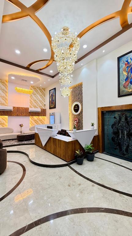a lobby with a chandelier and a fireplace at Hotel Aventus Grand in Indore