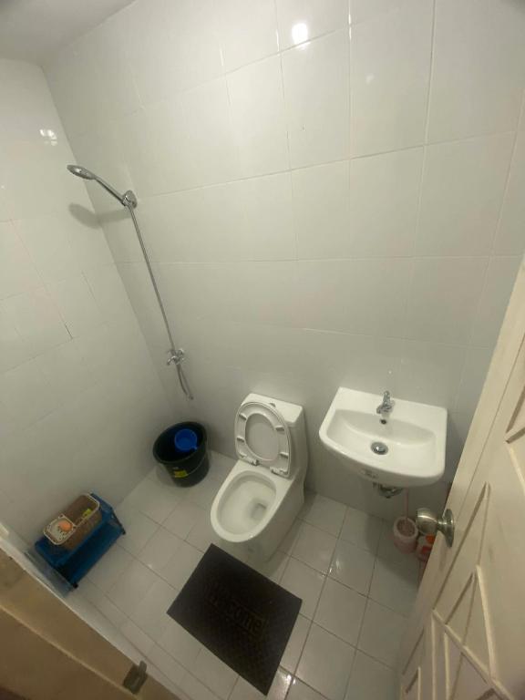 a small bathroom with a toilet and a sink at Two Br-House with Carport in Ormoc