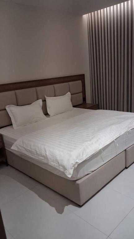 a bedroom with a large bed with white sheets at مساكن للشقق الفندقيه in Riyadh
