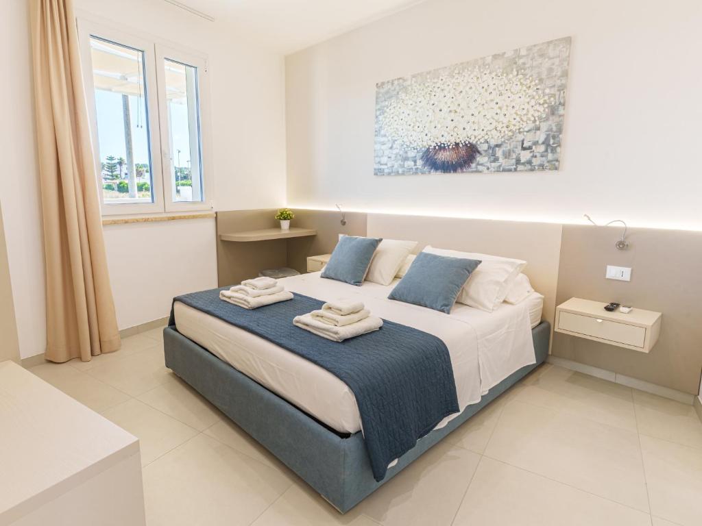 a bedroom with a bed with towels on it at Casa LE VELE in Torre Pali