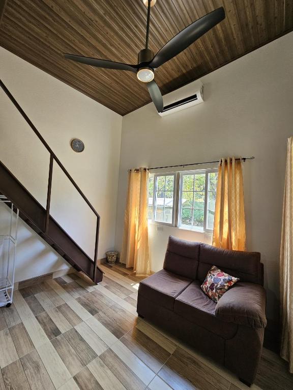 a living room with a couch and a ceiling fan at Chitos place in Savegre