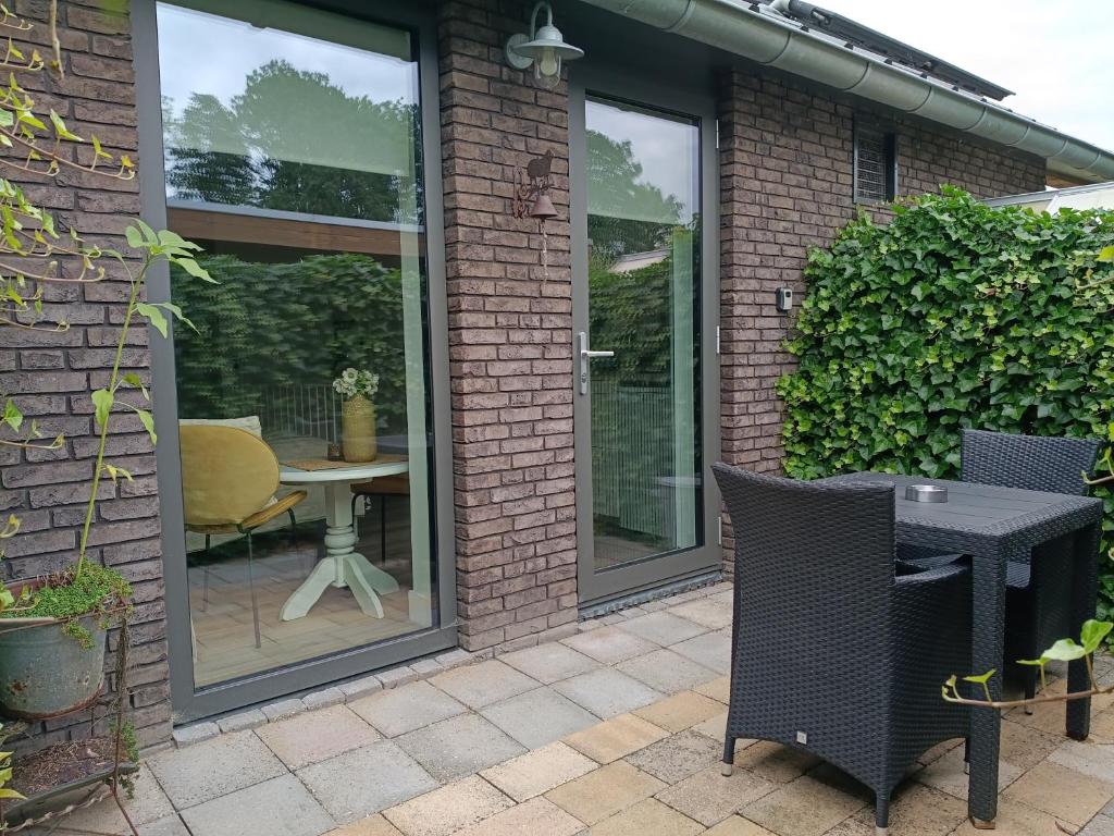 a patio with sliding glass doors with a table at The Two Branches in 't Waal