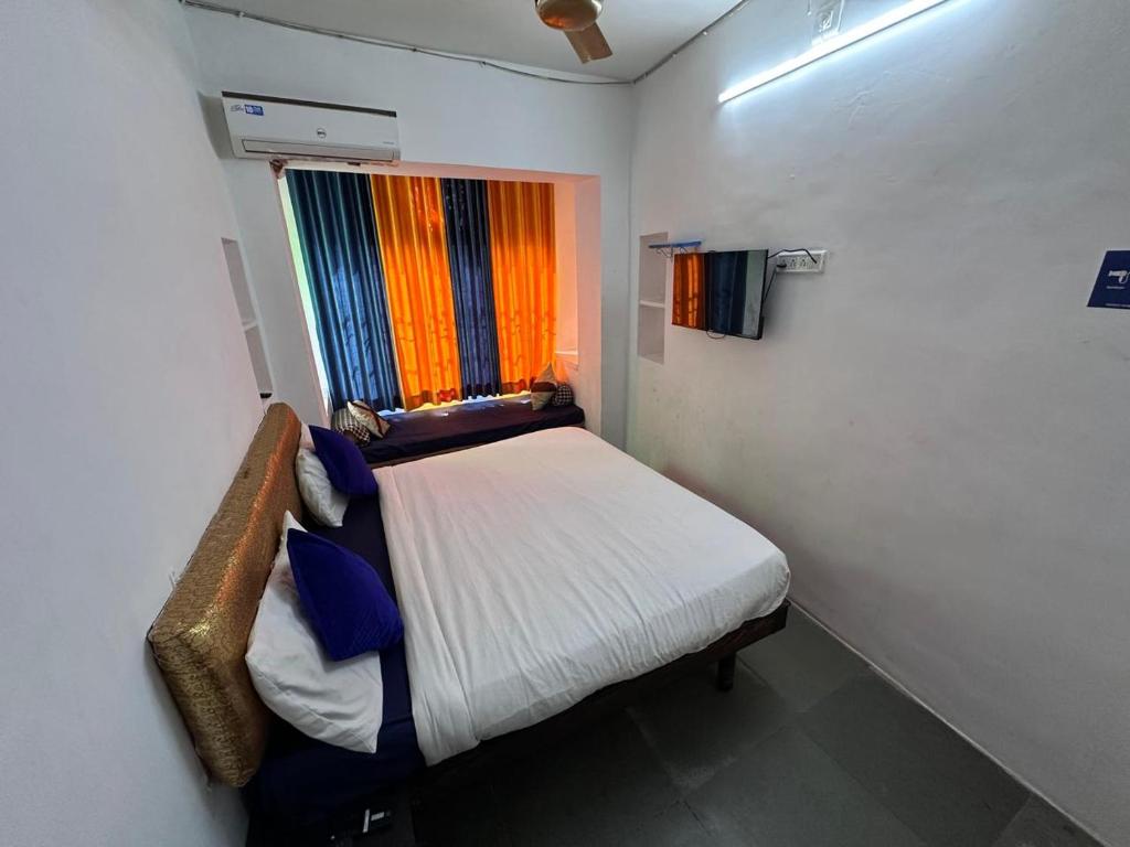 a small bedroom with a bed and a window at Happy Trails Hostel Udaipur in Udaipur