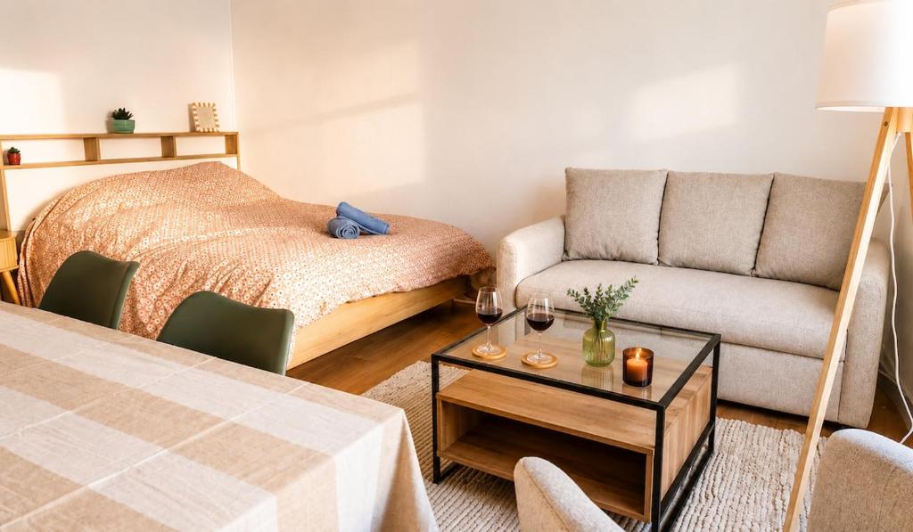 a room with a bed and a couch and a table at L'Écrin Bois & Lin in Nevers