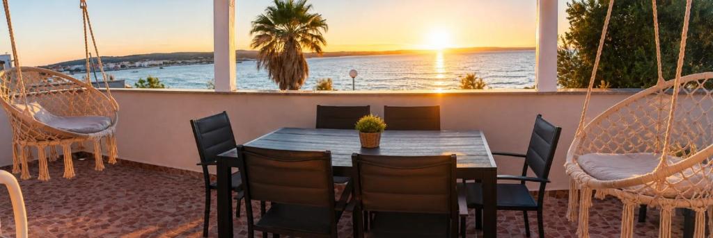 a table and chairs on a balcony with a view of the ocean at Graf-Apartments-Vir-Zadar in Vir