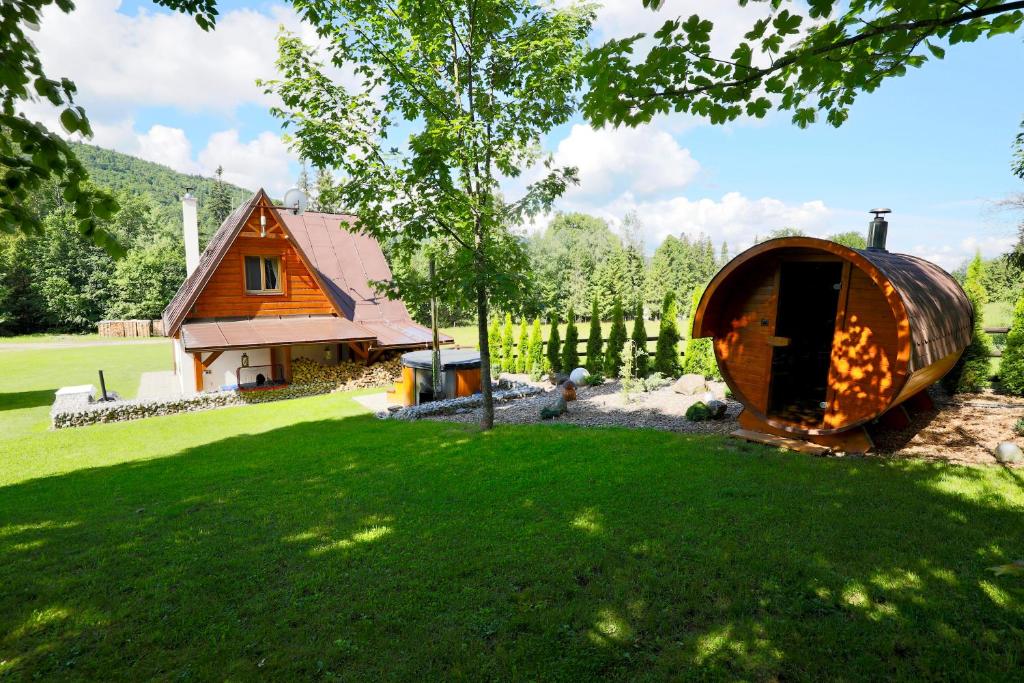 a round house in a yard next to a house at Chata na Zbojskej - Zbojská in Pohronská Polhora