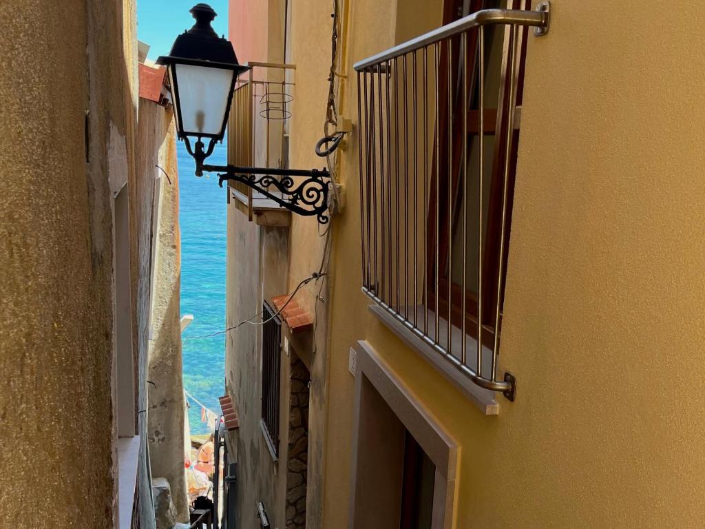 an alley with a street light and the ocean at Casetta IV Vico- Chianalea in Scilla