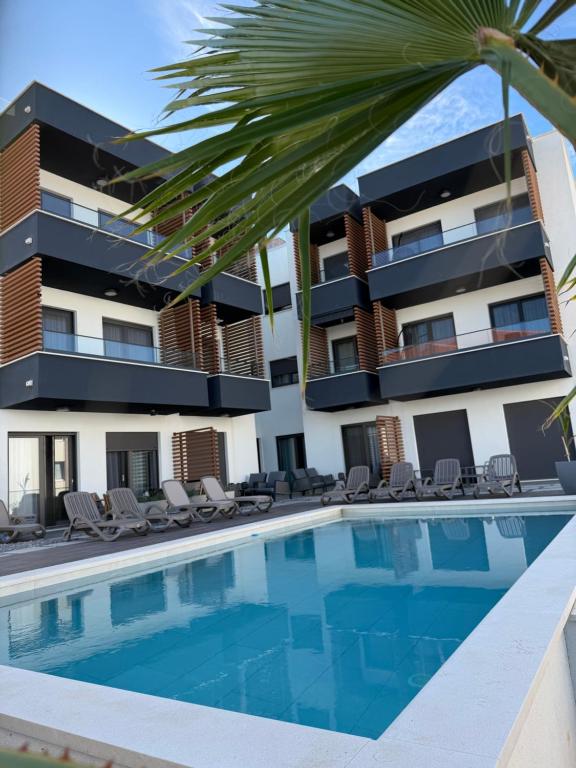a building with a swimming pool in front of a building at Slatine Residence apartament No2 in Slatine
