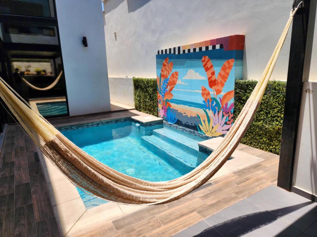 Eine Hängematte vor einem Haus mit Pool in der Unterkunft Casa Alvana - Sauna & Private Pool at Baja Country Club in Ensenada