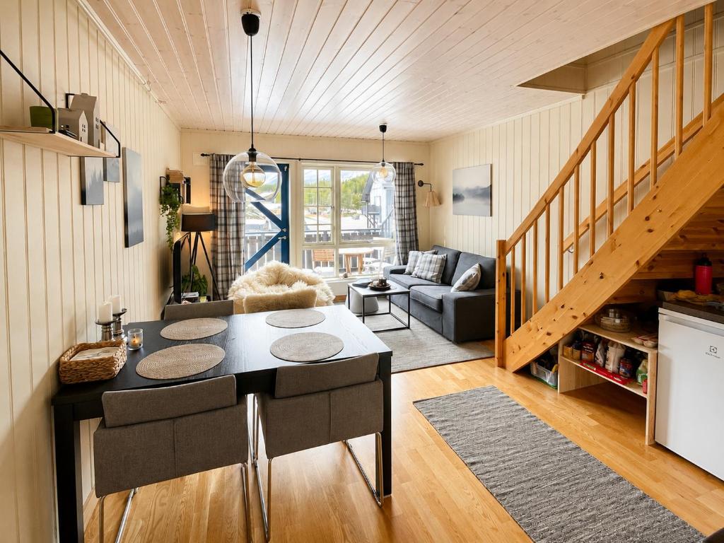 a kitchen and living room with a table and chairs at Alpintunet Uvdal in Sønstebø