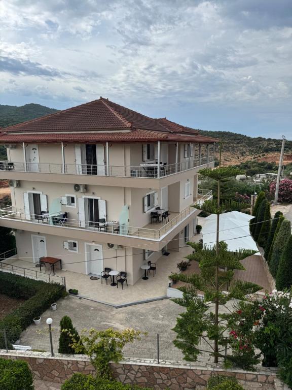 a large building with tables and chairs in a courtyard at Vila Ervin Double Room in Ksamil