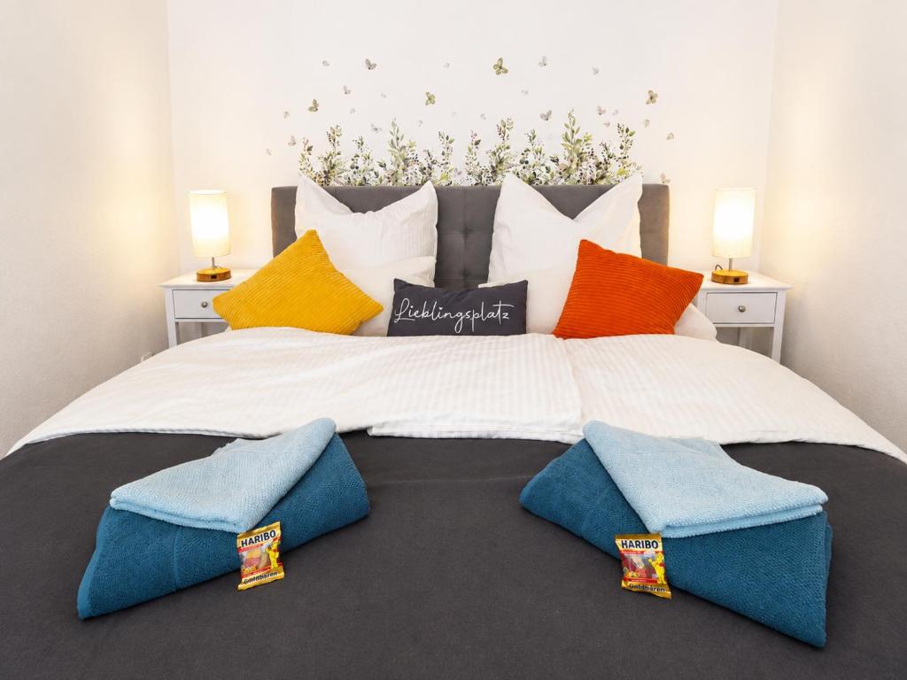 a large white bed with colorful pillows on it at Wohnung mit hist. Altstadt Charme in Nördlingen