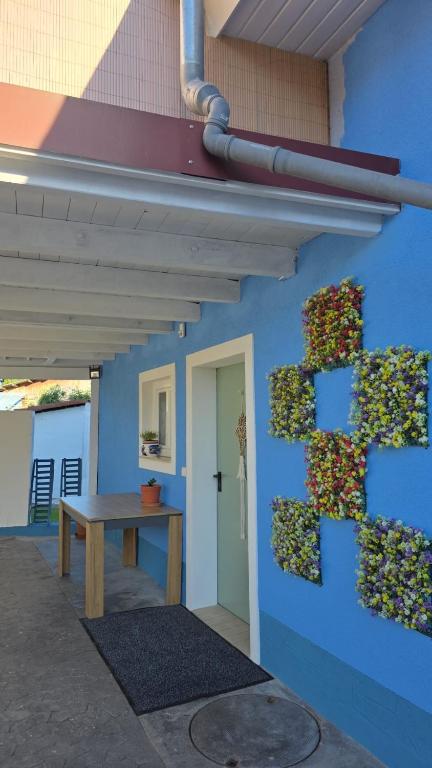 a building with a blue wall with a plant on it at Cozy & modern apartment in Willstätt in Willstätt