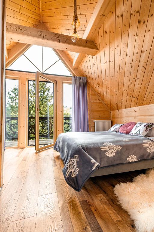 a bedroom with a bed in a wooden house at Górska Kryjówka in Poronin