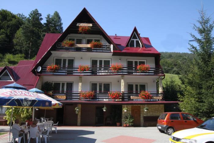 a large building with flowers on the balconies of it at Wiktorowa Chata in Wierchomla Wielka