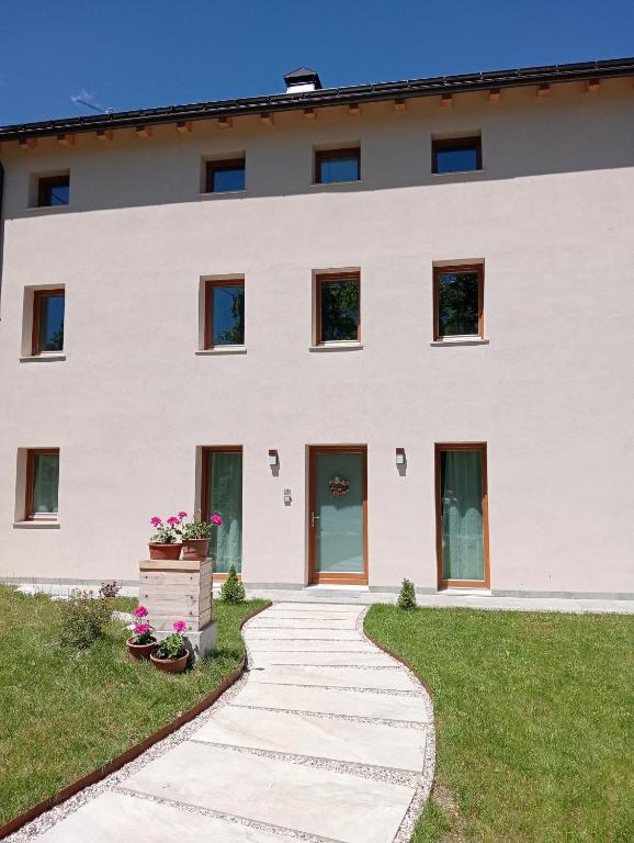 a white building with a walkway in front of it at Casa ecologica Ai Ronchi in Gallio
