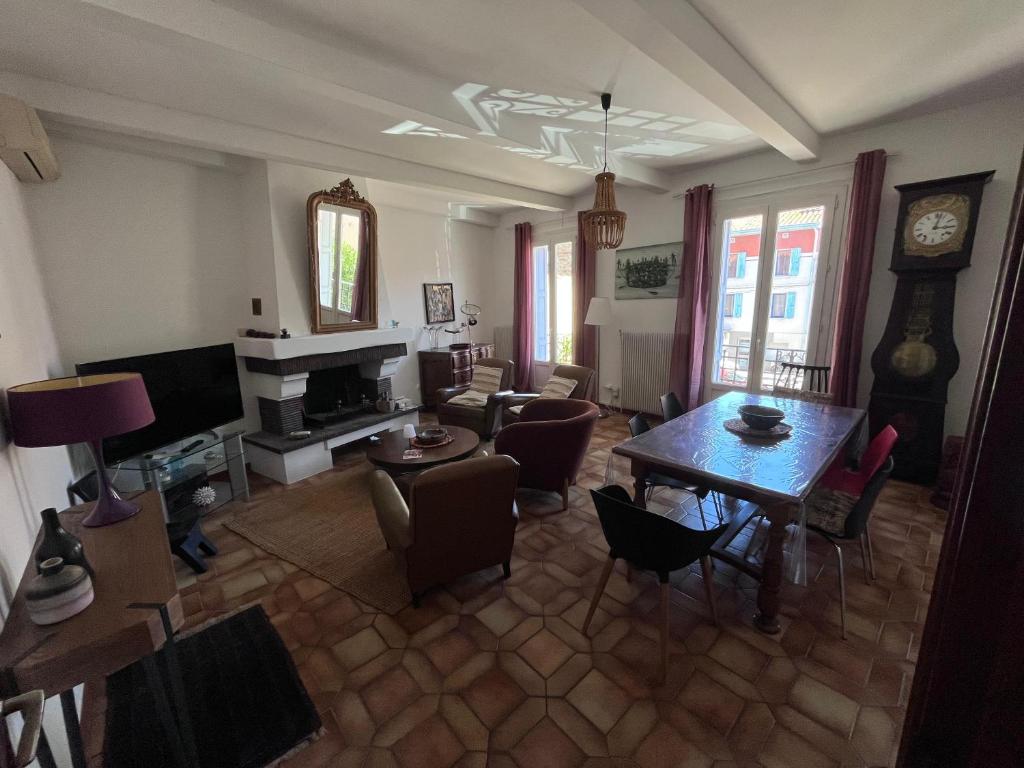 a living room with a table and a dining room at Grande maison familiale proche mer in Elne