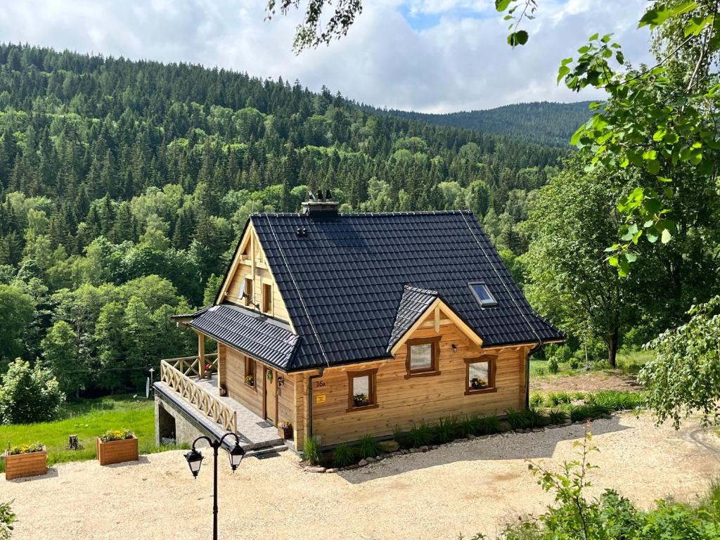 a large log cabin with a black roof at Górska Chata w Górach Bystrzyckich in Niemojów