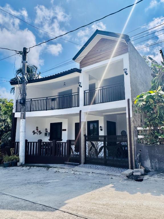 a white house with a black fence at D’Waldz Villa 2 Tagaytay in Tagaytay