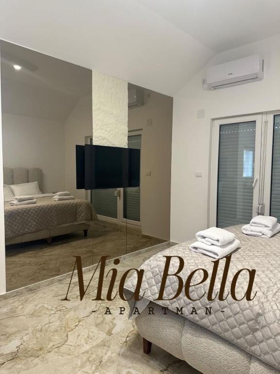 a bedroom with a bed and a tv in a room at Mia Bella in Sremska Kamenica