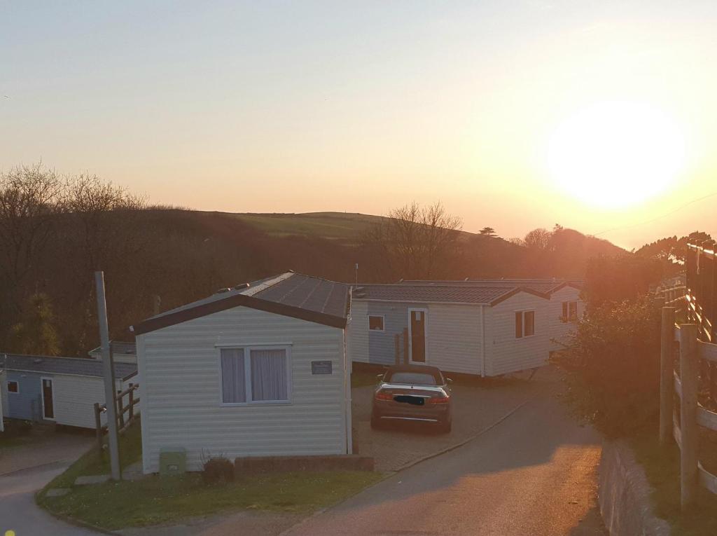 a house with a car parked in front of a street at Skipper's Place in Mortehoe