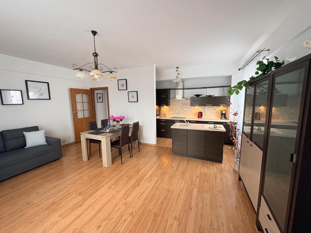 a living room with a table and a kitchen at Płock City Center Apartment in Płock