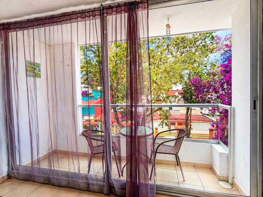 a balcony with a table and chairs and a window at Loft Sipeh Xalapa Departamento 4 in Xalapa