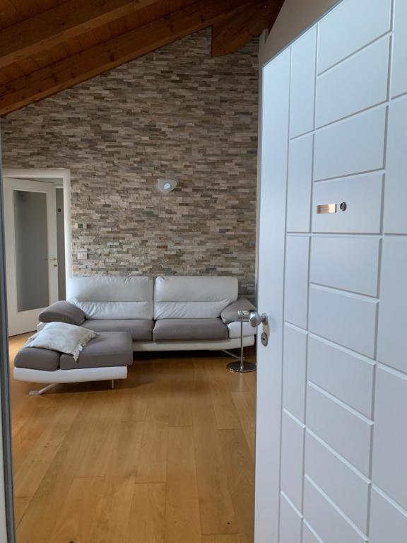 a living room with a couch and a brick wall at Il Rifugio di Palmanova in Palmanova