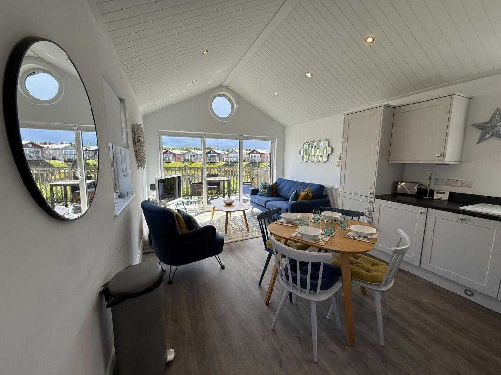 a kitchen and living room with a table and chairs at The Lake House, The Bay Filey, sleeps 4 in 2 double rooms with ensuites, 1 dog welcome in Filey