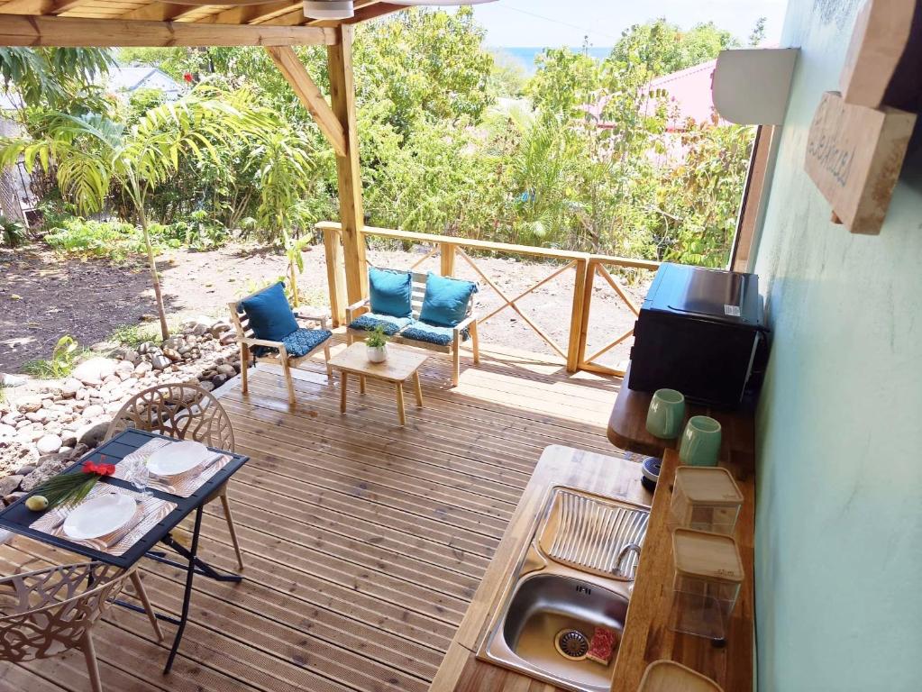 a deck with chairs and a sink and a table at Ti Colibri in Deshaies