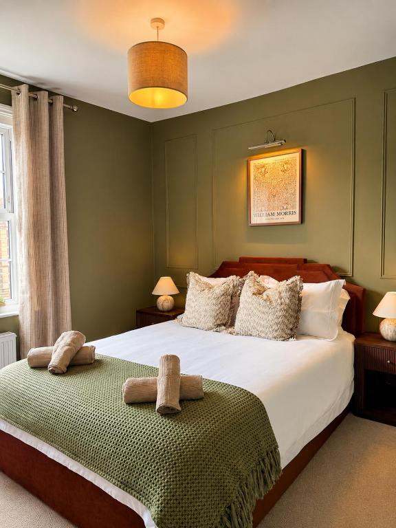 a bedroom with a large bed with two towels on it at St Johns Central Canterbury Cottage in Canterbury