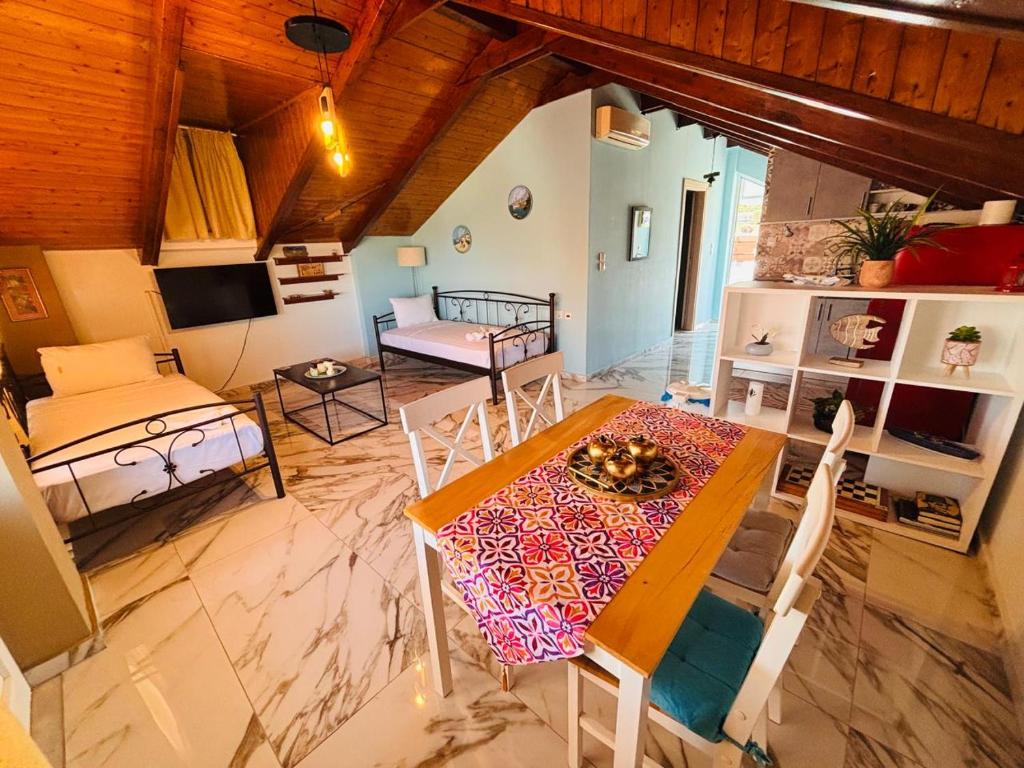 a living room with a table and a couch at HELEN STUDIOS Loft in Planos