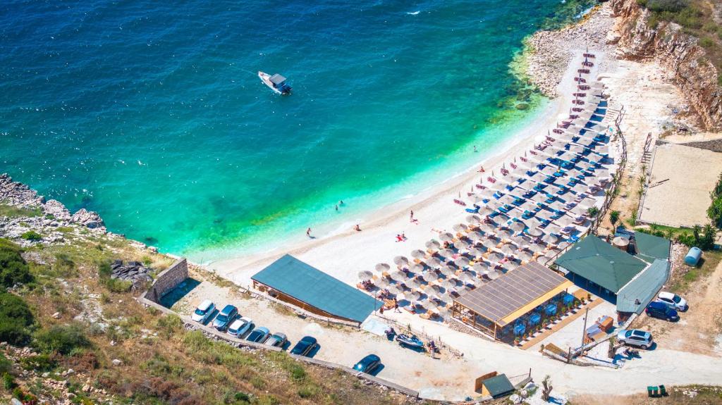an aerial view of a beach with umbrellas and the ocean at The Hidden Sea Rooms in Sarandë