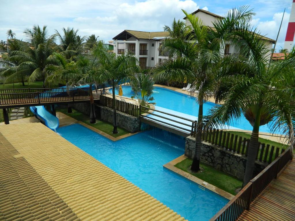 a view of a swimming pool with palm trees at Apartamento térreo com 3 quartos no Tree Bies- próximo do parque aquático infantil in Subaúma