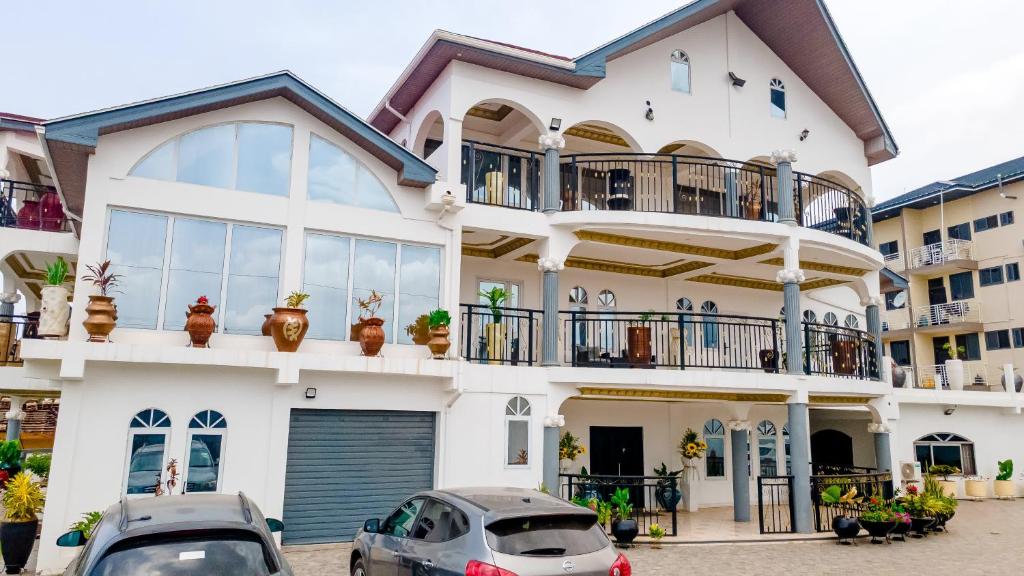 a white house with cars parked in front of it at XTENDED STAY Gh in Accra