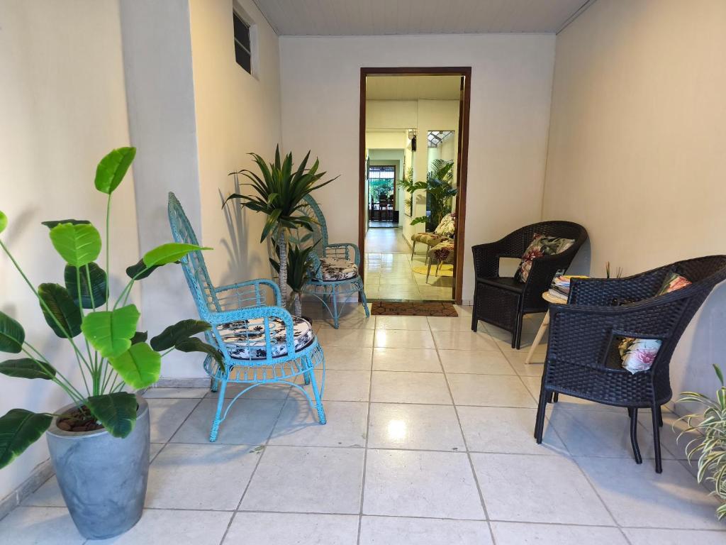 a living room with chairs and potted plants at Pousada Hangar- Seu familiar e aconchegante espaço em Belém in Belém